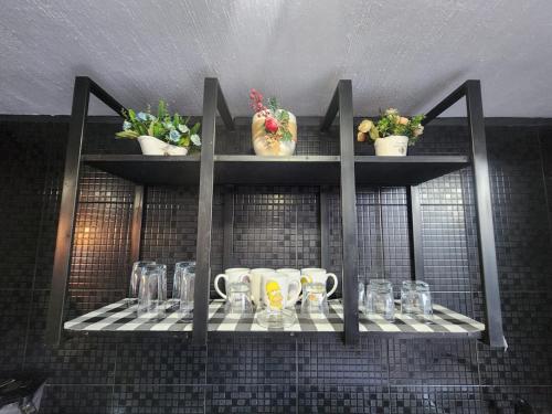 a shelf with cups and mugs on it at Casa entera, elegante, moderna in Guadalajara
