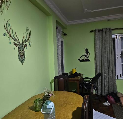 un comedor con una mesa y un ciervo en la pared en 2Bed Room Private Apartment, en Bākhri Kharka