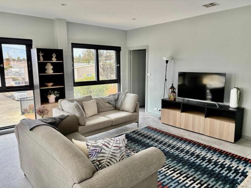 HarmanQuite and large 2 bedroom - Sleeps 6 - 2 bathrooms的配有沙发和平板电视的客厅