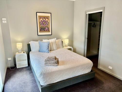 HarmanQuite and large 2 bedroom - Sleeps 6 - 2 bathrooms的一间卧室配有一张床和两张带台灯的桌子。