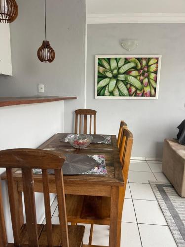ein Esstisch mit Stühlen und ein Gemälde an der Wand in der Unterkunft Lugar pra relaxar...Perto de tudo .. in Búzios