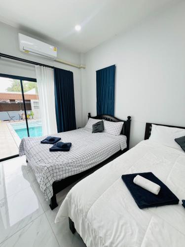 two beds sitting next to each other in a bedroom at TwoEightsix 286 Poolvilla in Ban Khun Thale