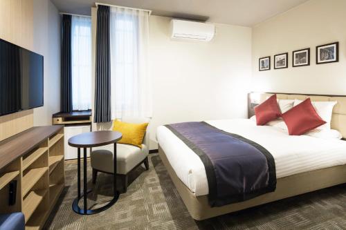 pokój hotelowy z łóżkiem i telewizorem w obiekcie HOTEL MYSTAYS Kanda w Tokio