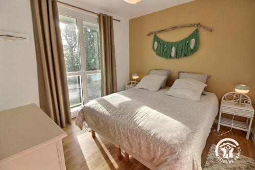 a bedroom with a large bed and a window at St christophe in Lézardrieux