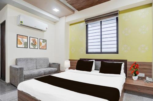 艾哈迈达巴德Super Hotel O Naroda GIDC Formerly Yuvraj的一间带床、沙发和窗户的卧室