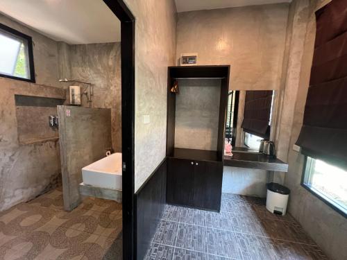 ein Badezimmer mit Badewanne, Waschbecken und Spiegel in der Unterkunft Chill Villa in Ban Pak Nam Pran