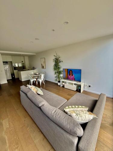 a living room with a couch and a tv at City-Self check in-Parking-Pool in Canberra