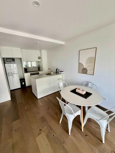 a kitchen and living room with a table and chairs at City-Self check in-Parking-Pool in Canberra