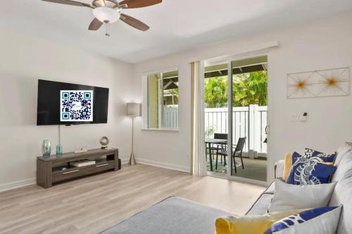a living room with a ceiling fan and a television at Hawaiian Dream Villa 1 mile from Disney Aulani in Honokai Hale