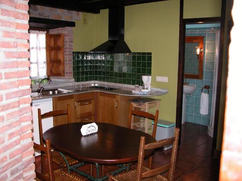cocina con mesa, fregadero y encimera en Apartamentos Rurales Colsa, en Colsa