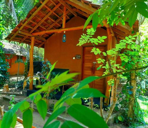 达瓦拉维Sandalwood Ayurvedic Spa & Safari Cottages的木头屋顶的小屋