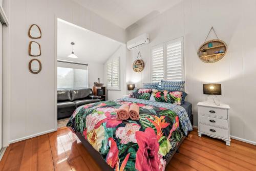 a bedroom with a bed with a colorful bedspread at Spacious and Charming Queenslander in Ipswich in Bundamba