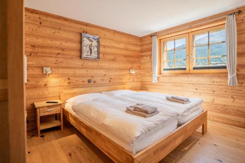 Marmo Apartment by HomeFlow في زيرمات: غرفة نوم بها سرير في جدار خشبي