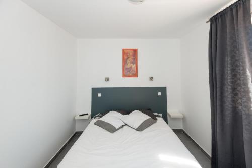 ル・グロー・ダグドにあるHôtel Restaurant le Voilisのベッドルーム1室(白いベッド1台、枕2つ付)