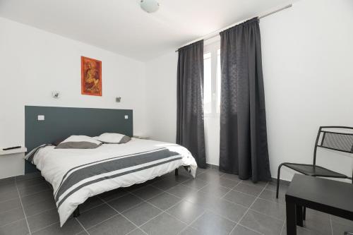 a bedroom with a bed and a window at Hôtel Restaurant le Voilis in Le Grau-dʼAgde