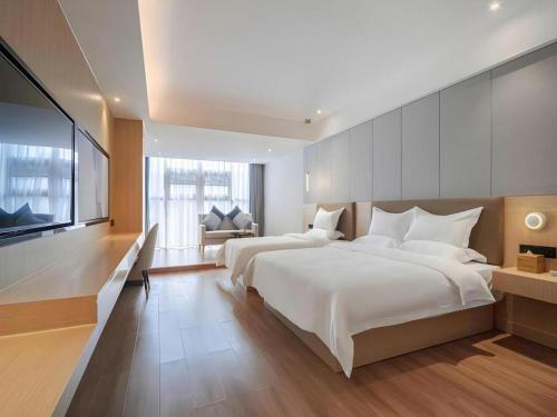 una grande camera con due letti e una TV a schermo piatto di Gya Hotel Chengdu Global Center Jinchenghu Metro Station a Chengdu
