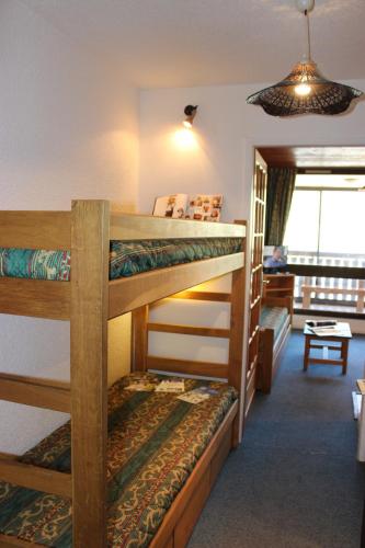 une chambre avec trois lits superposés dans une pièce dans l'établissement Serac Appartements VTI, à Val Thorens