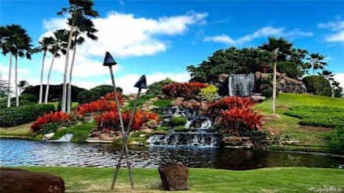 a garden with a waterfall and a pond with flowers at Beautiful 3 Bedroom Villa in Honokai Hale