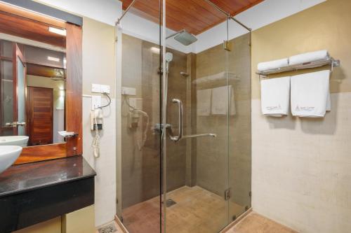 W łazience znajduje się szklana kabina prysznicowa i umywalka. w obiekcie Beach Corridor Hotel & Spa with Free Airport shuttle w Negombo