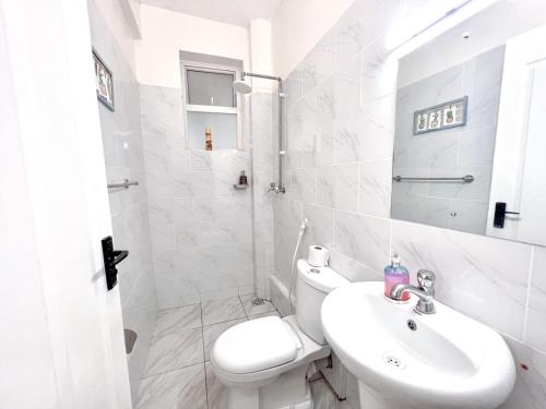 Un baño blanco con inodoro y lavabo. en Cosy apartments, en Mtwapa