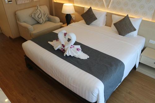 Una habitación de hotel con una cama con dos cisnes. en Baan Sailom Hotel Phuket - Sha Extra Plus, en Karon Beach
