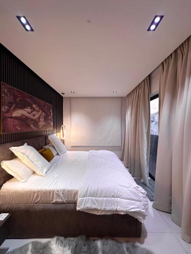 レッキにあるPanache by Hammersmithの白いシーツが敷かれた大きなベッドのある寝室