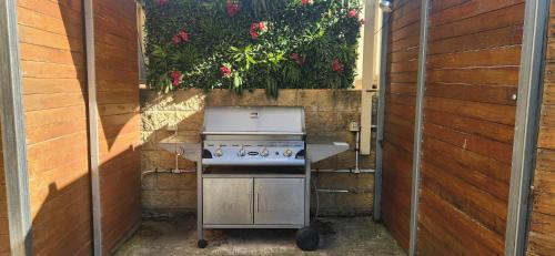 an outdoor kitchen with a stove in a garden at Motel On A'Beckett in Inverloch