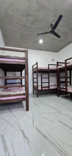 three bunk beds in a room with a ceiling at WoodPacker Hostel Auroville Pondicherry in Auroville