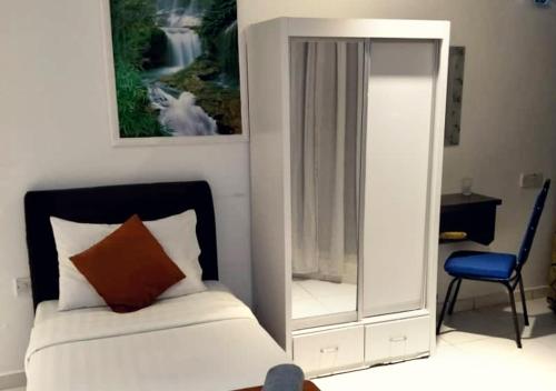 Un dormitorio con una cama con un espejo y una silla. en Hotel Double Star Klia, en Sepang