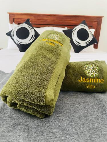 a green pillow sitting on top of a bed at Jasmine Villa in Bentota