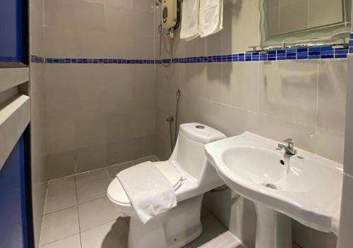 Un baño con un inodoro blanco y un lavabo. en Hotel Double Star Klia, en Sepang