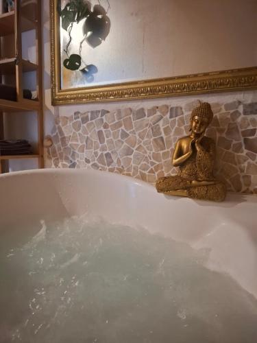 una statua di una donna seduta in una vasca da bagno di Maison Les Géraniums parking privé moto a Linthal