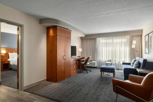 ein Hotelzimmer mit einem Bett und einem Wohnzimmer in der Unterkunft Courtyard Des Moines Ankeny in Ankeny