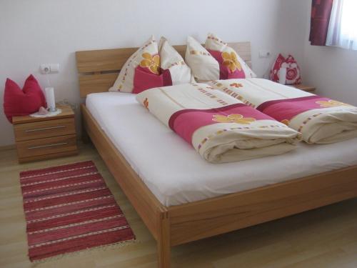 a bedroom with a large wooden bed with pillows at Apartment Galtenberg in Alpbach