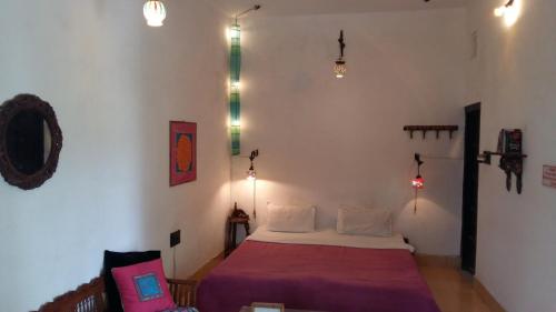 a bedroom with a bed in a room with lights at Inn Seventh Heaven in Pushkar