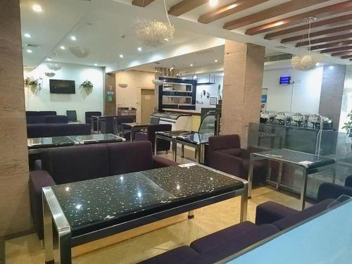 a restaurant with tables and chairs and a kitchen at GreenTree Inn Shenzhen Kengzi Town Express Hotel in Kengzi