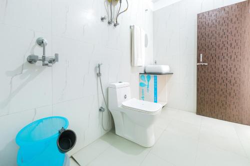 a white bathroom with a toilet and a shower at Hotel Vista, Nainital - A hidden gem away from city hustle in Nainital