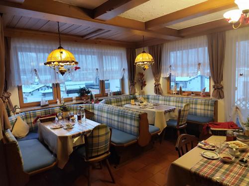 a restaurant with two tables and chairs and windows at Privatzimmer Pendl in Abtenau