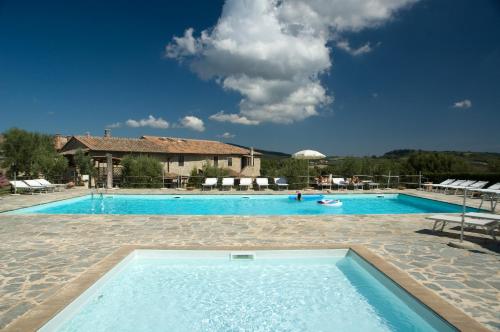 ein großer Pool vor einem Haus in der Unterkunft Tenuta Decimo - Il Borgo Di Mariano in San Gimignano
