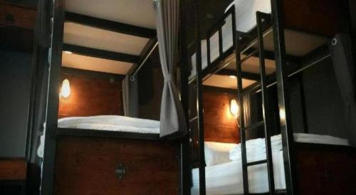 盼武里Rider bedroom hostel & cafe的带镜子的客房内的两张双层床