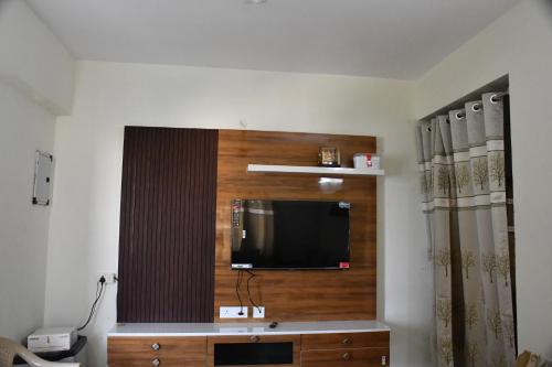 a living room with a flat screen tv on a wall at Elegant Beach View Flat , Bheemili in Bhīmunipatnam