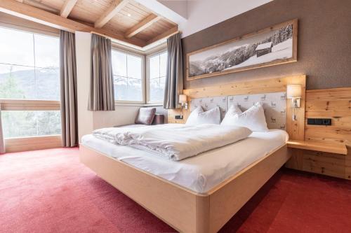 a bedroom with a large bed in a room with windows at LAUDEGGHOF Ladis in Ladis