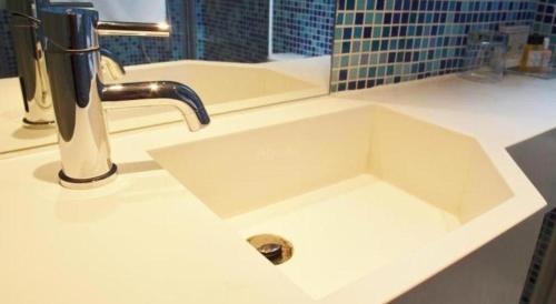 un lavandino bianco con un rubinetto in un bagno di Acesite Knutsford Hotel a Hong Kong