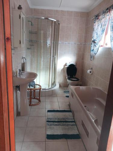 a bathroom with a tub and a sink and a toilet at Seesterkloof in Stilbaai