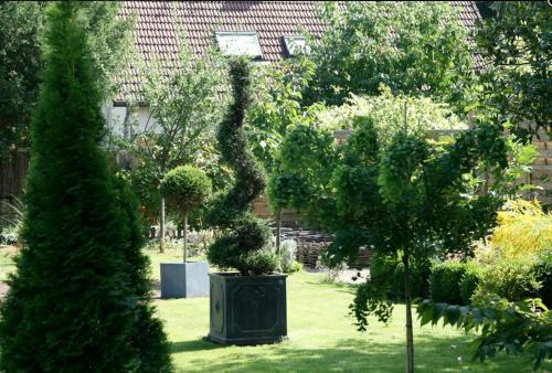 a garden with trees and a statue in the grass at Chambre d'Hôtes La Villa Molina in Besançon