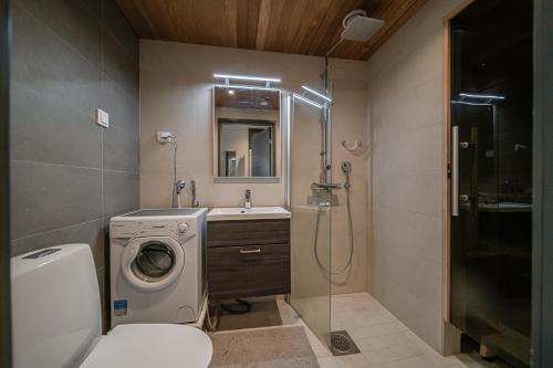 a bathroom with a washing machine and a sink at Lomavuokra Alpine Chalets Tunturinlaita B9 in Levi