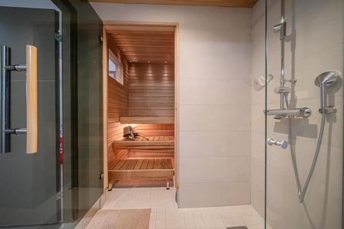 a sauna in a bathroom with a shower at Lomavuokra Alpine Chalets Tunturinlaita in Levi