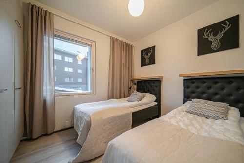 a bedroom with two beds and a window at Lomavuokra Alpine Chalets Tunturinlaita in Levi