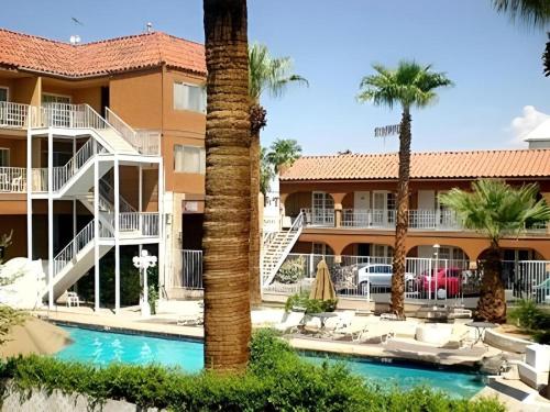 a resort with a swimming pool and palm trees at Shalimar Hostel in Las Vegas