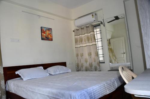 a small bedroom with a bed and a mirror at Elegant Beach View Flat , Bheemili in Bhīmunipatnam